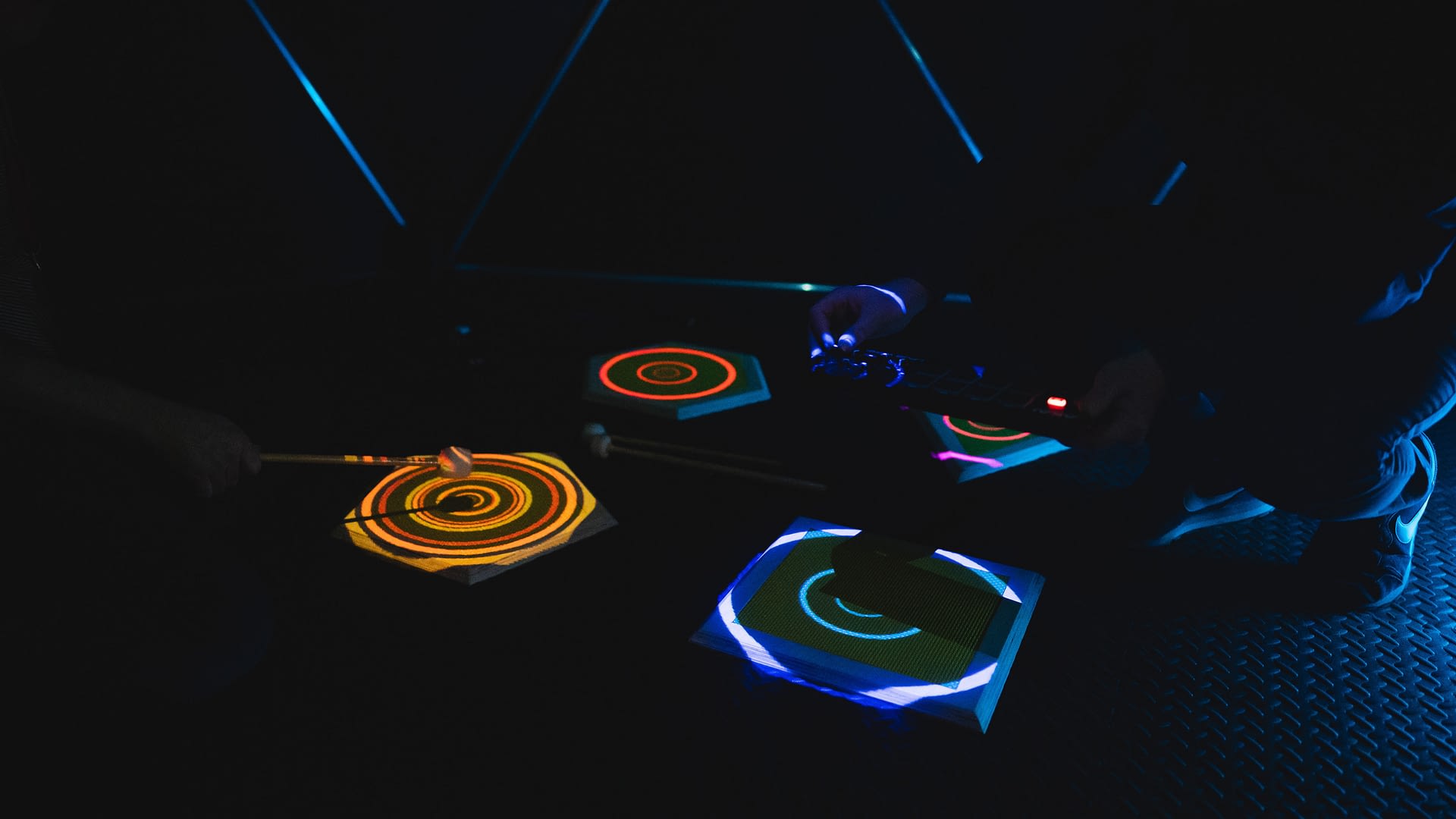 Circular multi-colour patterns projected onto pads are played with a drumstick